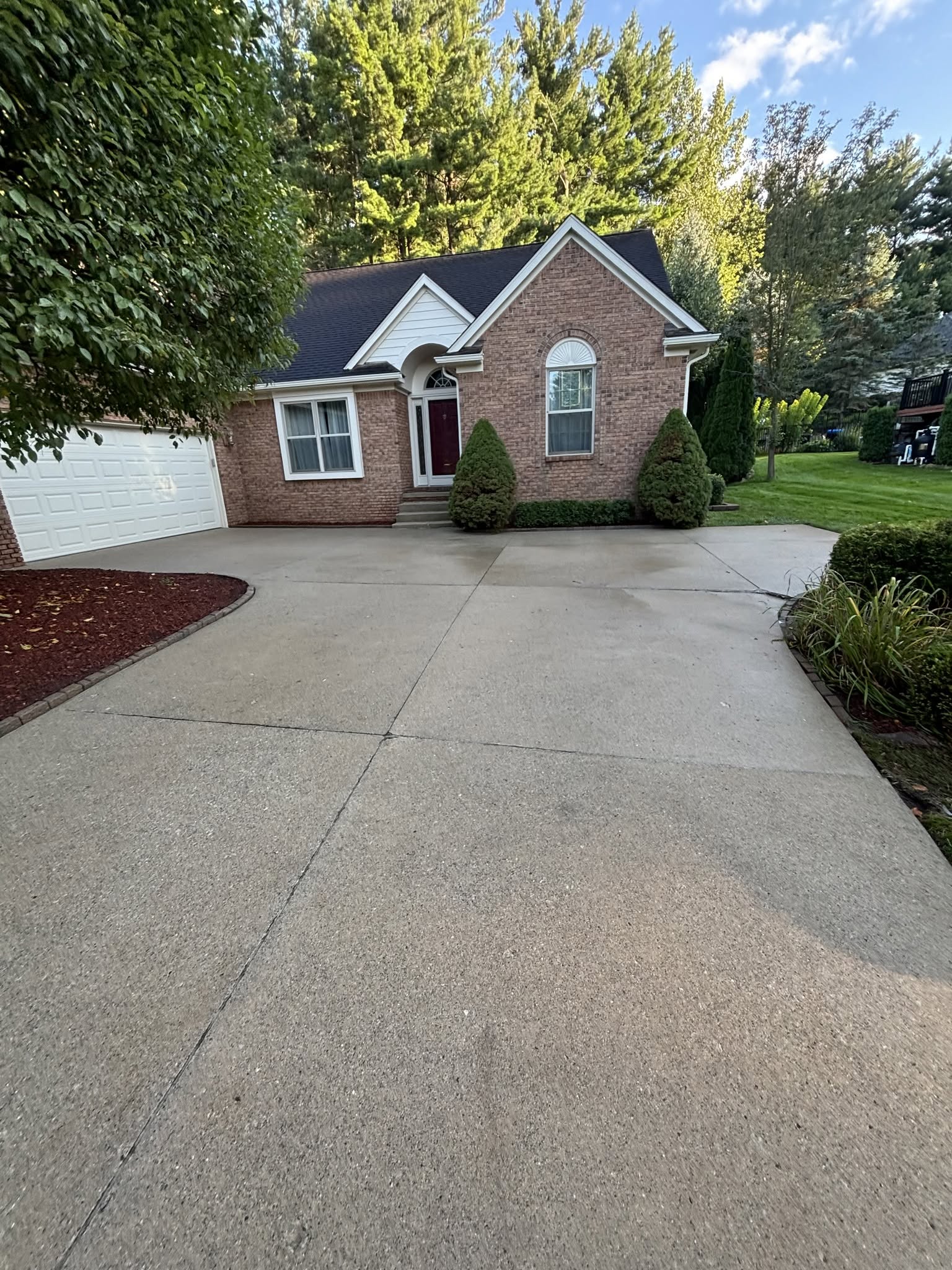 Finished concrete driveway for a brick home by Construction company Fenton, MI Jaybird Construction
