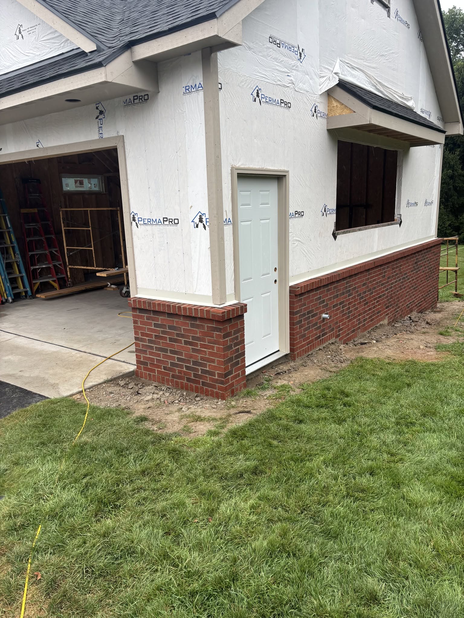 Garage addition with brick wainscoting and house wrap in Genesee County, Michigan